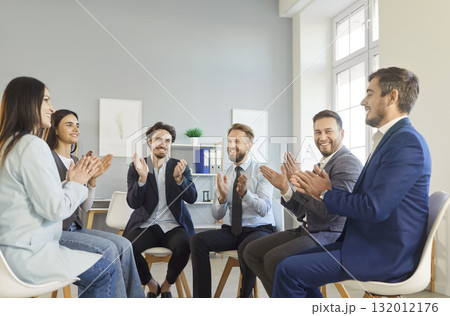 Happy smiling business team sitting in circle, clapping hands, celebrating success and team spirit. Happy smiling business team sitting in circle, clapping hands, celebrating success and team spirit. 132012176