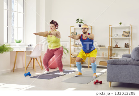 Funny plump woman doing squats with her personal trainer 132012209