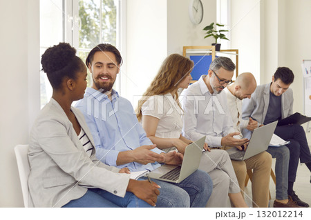 Diverse people communicate with each other during business training in office of business center. Diverse people communicate with each other during business training in office of business center. 132012214