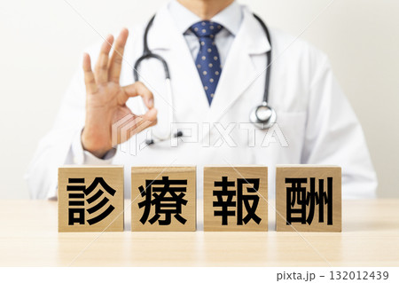 「診療報酬」と書かれたブロックとOKサインをする医師 132012439