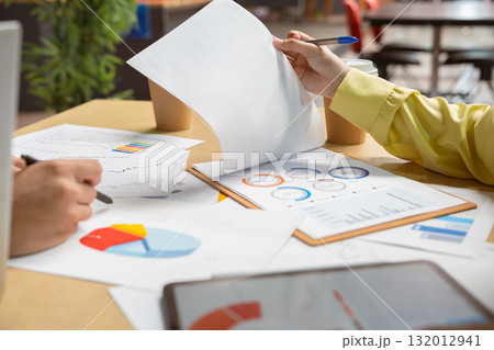 Business colleagues pointing at business document during discussion at meeting. Business people meeting explaining the financial graph data and marketing plan.Teamwork process. Business colleagues pointing at business document during discussion at meeting. Business people meeting explaining the financial graph data and marketing plan.Teamwork process. 132012941