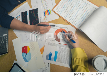 Business colleagues pointing at business document during discussion at meeting. Business people meeting explaining the financial graph data and marketing plan.Teamwork process. Business colleagues pointing at business document during discussion at meeting. Business people meeting explaining the financial graph data and marketing plan.Teamwork process. 132012943