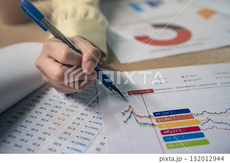 Business colleagues pointing at business document during discussion at meeting. Business people meeting explaining the financial graph data and marketing plan.Teamwork process. Business colleagues pointing at business document during discussion at meeting. Business people meeting explaining the financial graph data and marketing plan.Teamwork process. 132012944
