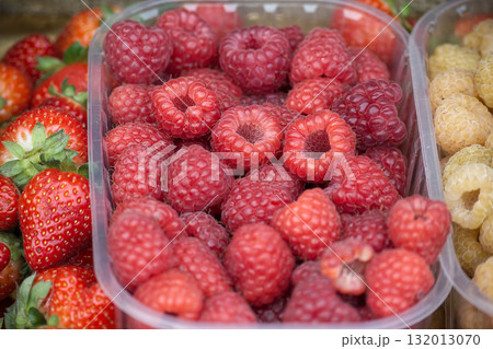 Fresh raspberries and strawberries in a clear container, ready to eat and enjoy. Fresh raspberries and strawberries in a clear container, ready to eat and enjoy. 132013070