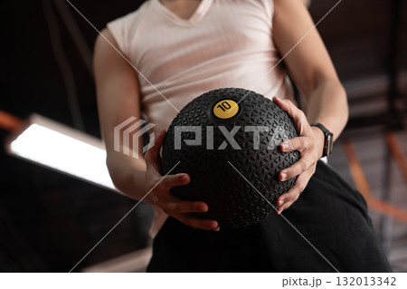 Young Asian man doing fitness workout with med ball in gym. 132013342