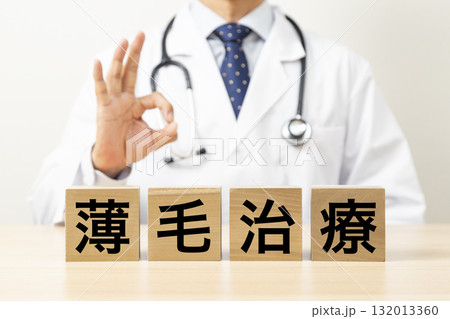 「薄毛治療」と書かれたブロックとOKサインをする医師 「薄毛治療」と書かれたブロックとOKサインをする医師 132013360