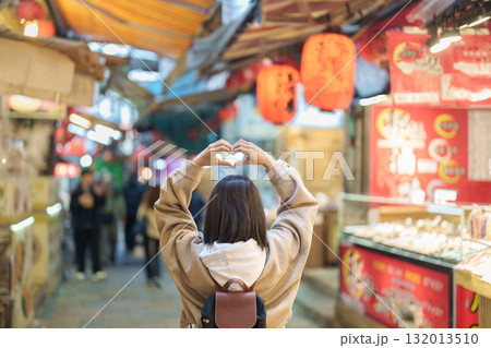 woman traveler visiting in Taiwan, female Tourist with backpack sightseeing and shopping at Jiufen Old Street market. Popular landmark and attractions near Taipei City. Travel and Vacation concept 132013510