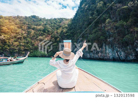 Happy Woman tourist in private longtail boat trip to koh Hong lagoon island at Krabi, Thailand. landmark, tropical destination, southeast Asia Travel, summer vacation, wanderlust and holiday concept Happy Woman tourist in private longtail boat trip to koh Hong lagoon island at Krabi, Thailand. landmark, tropical destination, southeast Asia Travel, summer vacation, wanderlust and holiday concept 132013598