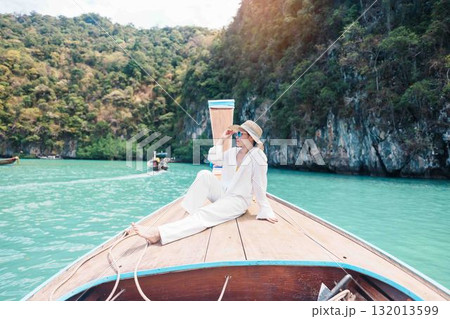 Happy Woman tourist in private longtail boat trip to koh Hong lagoon island at Krabi, Thailand. landmark, tropical destination, southeast Asia Travel, summer vacation, wanderlust and holiday concept Happy Woman tourist in private longtail boat trip to koh Hong lagoon island at Krabi, Thailand. landmark, tropical destination, southeast Asia Travel, summer vacation, wanderlust and holiday concept 132013599