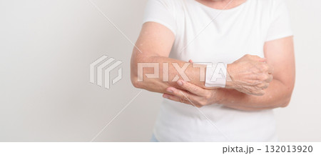 Elderly Woman having wrist pain with Medicated pain relief patch plaster for Carpal Tunnel Syndrome, Wrist Tendinitis, muscle ache, De Quervain s tenosynovitis, Hand Osteoarthritis and Senior health Elderly Woman having wrist pain with Medicated pain relief patch plaster for Carpal Tunnel Syndrome, Wrist Tendinitis, muscle ache, De Quervain s tenosynovitis, Hand Osteoarthritis and Senior health 132013920
