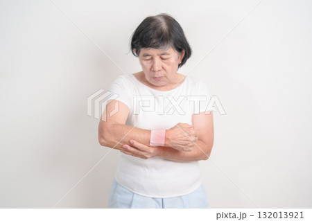 Elderly Woman having wrist pain with Medicated pain relief patch plaster for Carpal Tunnel Syndrome, Wrist Tendinitis, muscle ache, De Quervain s tenosynovitis, Hand Osteoarthritis and Senior health Elderly Woman having wrist pain with Medicated pain relief patch plaster for Carpal Tunnel Syndrome, Wrist Tendinitis, muscle ache, De Quervain s tenosynovitis, Hand Osteoarthritis and Senior health 132013921