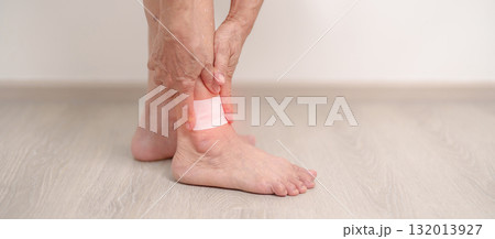 Elderly woman having leg pain with Medicated pain relief patch plaster for Ankle Sprains or Achilles Tendonitis and Shin Splints ache. injury, hyperuricemia disease, Gout and Senior Health care 132013927