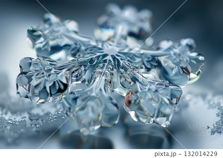Intricate crystal snowflake design glistening on a frosty surface with a cool blue background 132014229