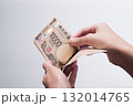 手に持った10万円分の一万円札を数える写真 (新紙幣・渋沢栄一・白バック) 132014765