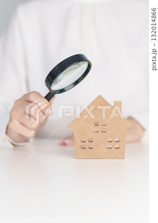 Hand hold magnifying glass over House model. mortgage, immovable assets investment, Property Inspection, Searching for real estate, purchase and rental home concept 132014866