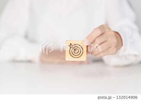 hand hold dartboard block with business goal, strategy, target, mission, action, objective, aim and success concept 132014906