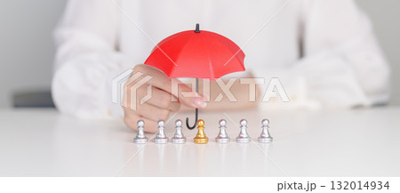 hand holding red umbrella and cover chess men from crowd of employees. People, Business, Human resource management, Life Insurance, Teamwork and leadership Concepts hand holding red umbrella and cover chess men from crowd of employees. People, Business, Human resource management, Life Insurance, Teamwork and leadership Concepts 132014934