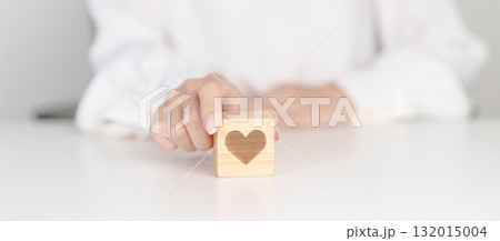 Hand holding heart block for health care, love, organ donation, charity, happy family, wellbeing and insurance concepts. world heart day, health day and mental health day Hand holding heart block for health care, love, organ donation, charity, happy family, wellbeing and insurance concepts. world heart day, health day and mental health day 132015004