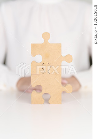 Woman connecting couple puzzle piece, wood jigsaw on table. Business solutions, mission, success, goals, strategy, Teamwork, Idea, Solution and challenge concepts Woman connecting couple puzzle piece, wood jigsaw on table. Business solutions, mission, success, goals, strategy, Teamwork, Idea, Solution and challenge concepts 132015018