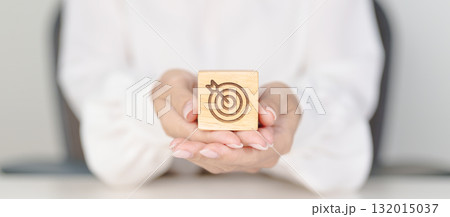 hand hold dartboard block with business goal, strategy, target, mission, action, objective, aim and success concept 132015037