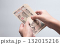 手に持った現金10万円を手渡す・受け取る写真 (新紙幣・一万円札・渋沢栄一・白バック) 132015216