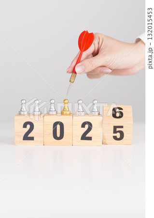 Hand holding red dart over people chess and 2026 year blocks. Goal, plan, action, target, strategy, leadership, New Year and marketing concept Hand holding red dart over people chess and 2026 year blocks. Goal, plan, action, target, strategy, leadership, New Year and marketing concept 132015453