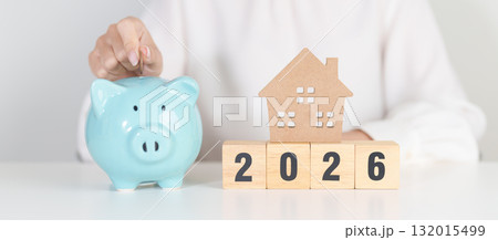 Happy New Year 2026 with house model and Coins stack. real estate, Home loan, tax, investment, mortgage, financial, savings and New Year Resolution concepts 132015499