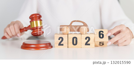 2025 end year to Happy New Year 2026 with small toy car models and Judges gavel on desk in courthouse. Car Law, Insurance, auto Tax, Auction and Bidding concepts 132015590