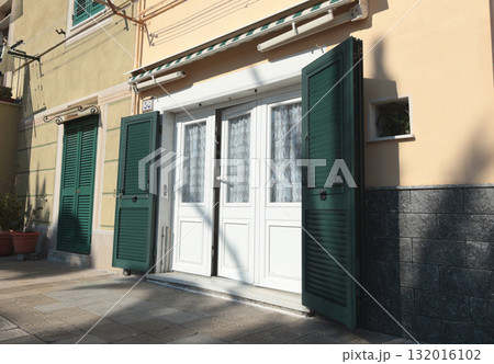 Old street, road in Italian countryside near sea. Traditional building. Sun day. Entrance, window to house. Nature and flowers.  132016102