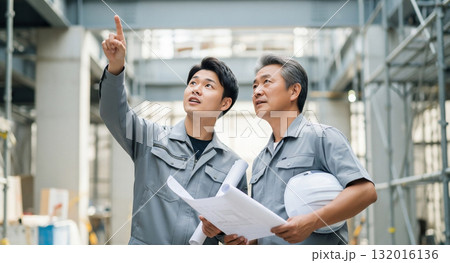 建築現場で打ち合わせをする人 132016136
