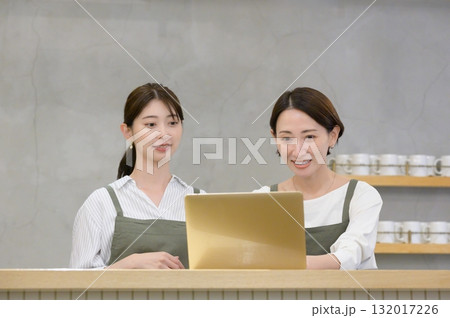 カフェの受付でパソコンを見て悩む日本人女性 132017226