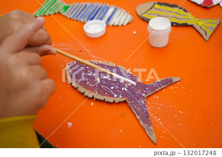 Design a fish figure from cardboard, thread, and paint, with detailed instructions, on an orange background. 132017248