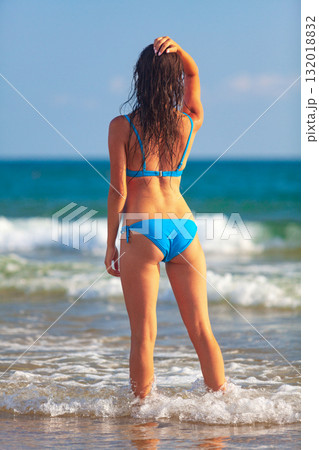 Pretty woman in blue bikini posing on a sea beach Pretty woman in blue bikini posing on a sea beach 132018832