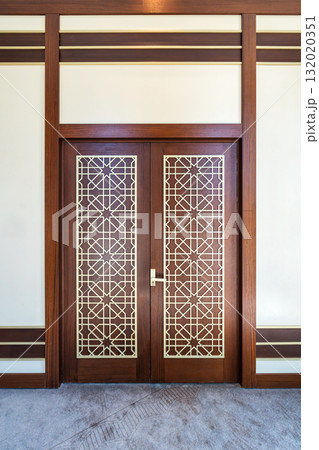 Modern wooden double door with intricate golden Islamic geometric patterns. Interior view 132020351