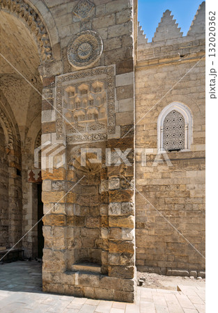 Architectural details of The Mosque of al-Zahir Baybars exterior, featuring carved stone and a patterned window, Cairo, Egypt. 132020362
