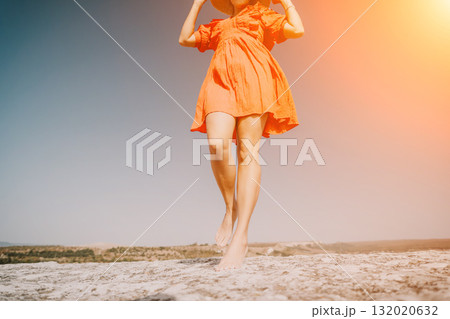 Woman in Orange Dress Walking on a Cliff 132020632