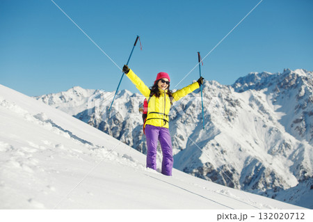 Joyful Female Mountaineer Celebrates Summiting Snowy Peak With Trekking Poles on Sunny Winter Day Joyful Female Mountaineer Celebrates Summiting Snowy Peak With Trekking Poles on Sunny Winter Day 132020712