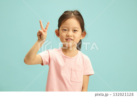Cute Asian ethnicity Child Giving Peace Sign, studio isolated portrait over blue isolated Cute Asian ethnicity Child Giving Peace Sign, studio isolated portrait over blue isolated 132021128