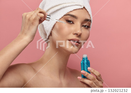 Asian girl in white hair turban using serum, retinol. 132021232