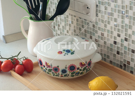 Retro-style ceramic tureen with lid floral patterns. Food in kitchen. Interior design and style. Mosaic tiles and kitchen countertops. Retro-style ceramic tureen with lid floral patterns. Food in kitchen. Interior design and style. Mosaic tiles and kitchen countertops. 132021591