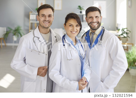 Smiling doctors in white coats standing in office, symbolizing teamwork and commitment to care. Smiling doctors in white coats standing in office, symbolizing teamwork and commitment to care. 132021594