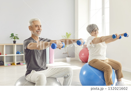 Elderly Family Couple Doing Dumbbell Exercises With Fitball In Gym 132021602
