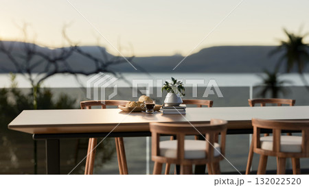 Breads on plate next to coffee cup on a long table with armchair on terrace or rooftop of restaurant 132022520