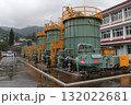 Industrial tanks and equipment on a wet platform. Possible factory compression station under cloudy sky. Infrastructure is visible 132022681