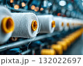A close up shows neatly arranged spools of yarn, highlighting the textures and organization of this textile factory and its industry materials 132022697