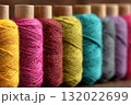 Close-up shows a row of colorful spools of thread, capturing the textile artistry and craftsmanship inherent in sewing and handmade goods 132022699