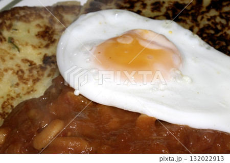 Close up of Fresh egg frying in a pan with golden yolk Close up of Fresh egg frying in a pan with golden yolk 132022913