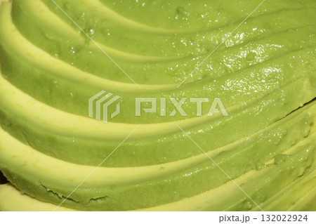 Close up of green fresh avocado sliced on chopping board 132022924
