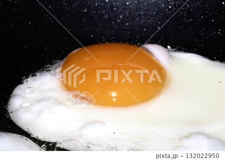 Close up of Fresh egg frying in a pan with golden yolk 132022950