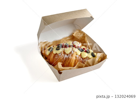 croissant topped with blueberry glaze and strawberry crumble in a cardboard lunch box croissant topped with blueberry glaze and strawberry crumble in a cardboard lunch box 132024069